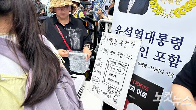 15일 서울역 광장에서 열린 '광화문 국민대회'에서 윤석열 전 대통령의 친필 싸인 책을 판매하는 윤 전 대통령 지지자들의 모습. 박인 기자