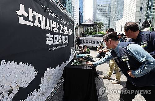 산재사망 건설노동자들을 위한 헌화 4월 23일 서울 중구 서울고용노동청 앞에서 열린 산재사망 건설노동자 추모 위령제에서 참가자들이 헌화하고 있다.[연합뉴스 자료사진]