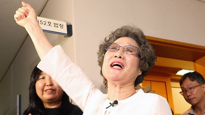 1964년 자신을 성폭행하려던 남성의 혀를 깨물어 중상해 혐의 유죄 판결을 받았던 최말자씨가 지난달 23일 부산지법에서 열린 재심 첫 공판을 마치고 법정을 나서며 손을 치켜 들며 "이겼습니다"를 외치는 모습. 이날 검찰은 "정당방위가 인정된다"며 무죄를 구형했다. /연합뉴스