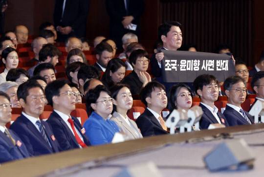 안철수 국민의힘 의원이 지난 15일 서울 세종문화회관에서 열린 80주년 광복절 경축식에서 '조국·윤미향 사면 반대'라는 문구가 적힌 펼침막을 들어보이고 있다. 연합뉴스