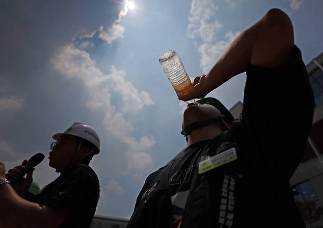 지난 7월28일 서울 종로구 국정기획위원회 건물 앞에서 민주노총 건설노조가 폭염 실태를 알리는 기자회견을 여는 가운데, 한 노동자가 물을 마시고 있다. 연합뉴스