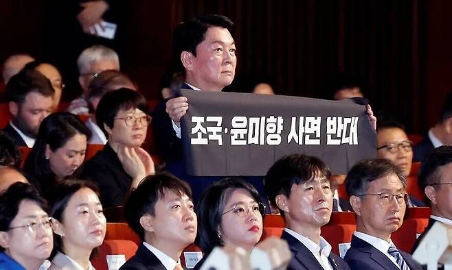 안철수 국민의힘 의원이 15일 서울 세종문화회관에서 열린 80주년 광복절 경축식에서 이재명 대통령이 경축사를 마치고 자리로 향할 때 \'조국·윤미향 사면 반대\'라는 문구가 적힌 펼침막을 들어 보이고 있다. 대통령실사진기자단