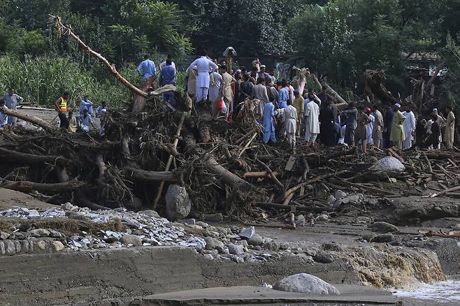 현지시각 16일 기습 폭우로 인한 홍수 피해를 입은 파키스탄 북서부 카이버파크툰크와주 부네르 지구에서 구조당국과 주민들이 피해자들의 시신을 수습하고 있다. AFP/연합뉴스
