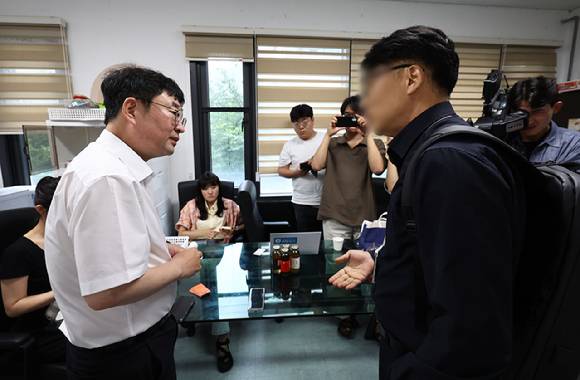 유튜브 채널 '신의한수' 운영자 신혜식 대표(왼쪽)가 13일 서울 마포구 사무실에서 윤석열 정부 시절 대통령실의 민간인 시위대 동원 의혹과 관련해 서울경찰청 안보수사과 수사관들에게 휴대전화를 임의제출 하기 전 잠시 대화하고 있다. 2025.8.13 [사진=연합뉴스]
