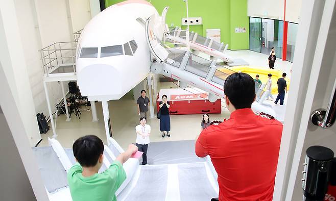 객실 승무원 체험과정 ‘크루 클래스’에 참여한 세이브더칠드런 아동·청소년들이 지난 12일 티웨이항공 훈련센터에서 A330 항공기 슬라이드 훈련을 체험하고 있다.