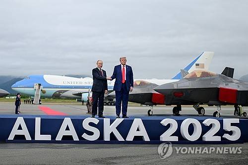 미 공군 F-22 전투기가 도열된 활주로 무대에서 악수하는 트럼프와 푸틴  [알래스카 UPI=연합뉴스. 재판매 및 DB 금지]
