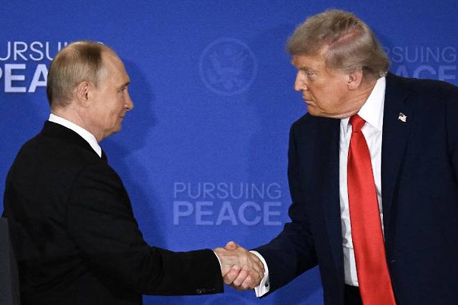도널드 트럼프 미국 대통령과 블라디미르 푸틴 러시아 대통령이 알래스카 주 앵커리지의 엘름도르프-리차드슨 합동기지에서 우크라이나 문제를 논의하기 위한 미국-러시아 정상회담에 참석한 후 공동 기자회견을 마치고 악수를 나누고 있다. (사진=AFP)