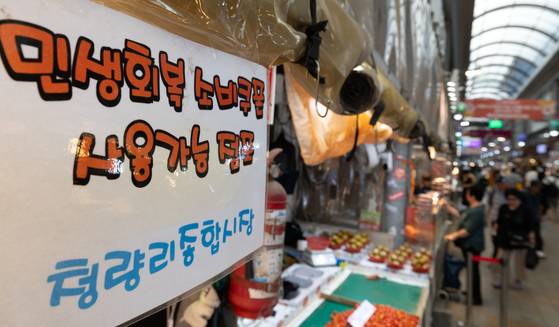 서울의 한 전통시장에 소비쿠폰 사용 가능 점포 안내문이 게시돼 있다. 뉴스1