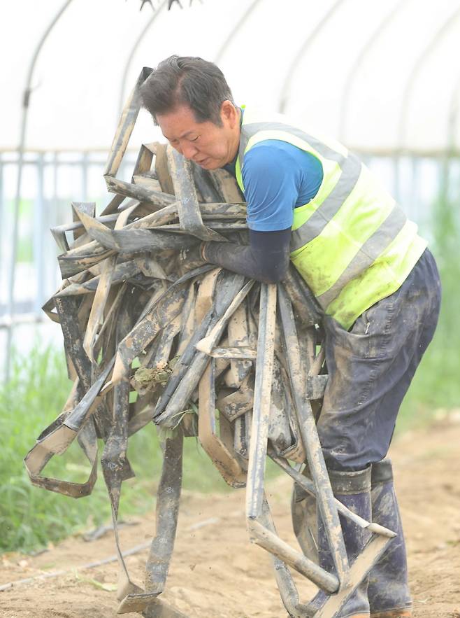 정청래 더불어민주당 대표가 지난 3일 오전 전남 나주시 노안면 오이농가를 찾아 수해 복구 작업을 하고 있다. 연합뉴스