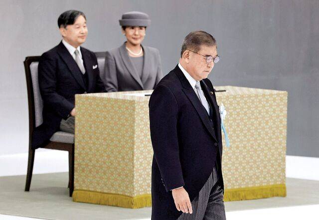 이시바 시게루 일본 총리가 패전 80년을 맞아 15일 도쿄 일본무도관에서 열린 ‘전국 전몰자 추도식’에서 추도사를 마친 뒤 나루히토 일왕 부부 옆을 지나가고 있다. AP연합뉴스