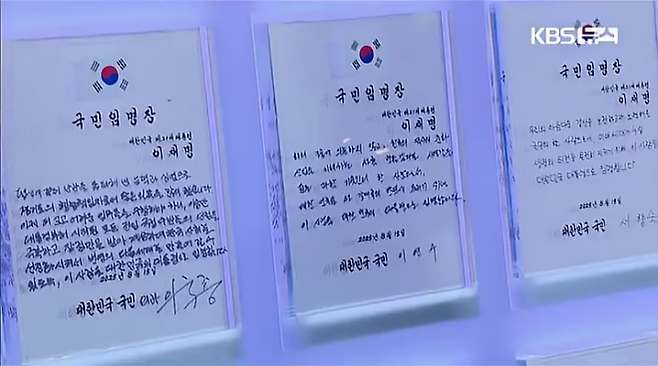 지난 15일 서울 세종대로 광화문광장에서 열린 제21대 대통령 국민임명식 ‘광복80년, 국민 주권으로 미래를 세우다’ 행사에서 이국종 국군대전병원장이 작성한 임명장이 무대 위 큐브에 거치되어 있다. [사진 = KBS 보도영상 캡처]