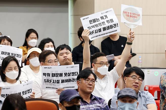 14일 오전 광주 남구 양과동 광역위생 매립장 내 가연성폐기물 연료화시설(SRF)에서 열린 악취 해결을 위한 간담회에서 주민들이 손팻말을 들고 있다. [연합]