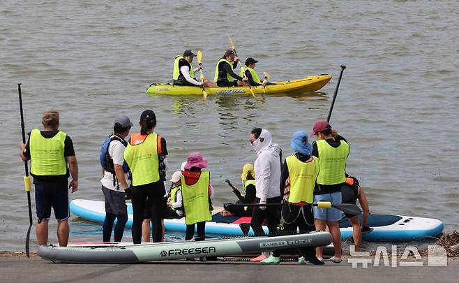 [서울=뉴시스] 권창회 기자 = 17일 서울 마포구 난지한강공원에서 시민들이 2025 한강페스티벌의 일환인 '카약 타Go, 패들보드 타Go' 행사를 즐기고 있다. 2025.08.17. kch0523@newsis.com
