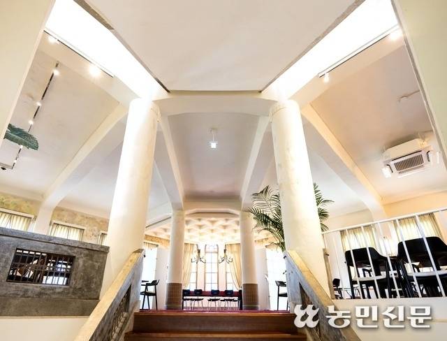 둥근 기둥과 아치형 창문, 붉은색 카펫으로 장식된 화신연쇄점 카페 내부.