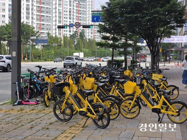 18일 오전 화성시 동탄 목동의 버스정류장 인근 개인형 이동장치(PM)가 쌓여 있는 모습. 5개  노선의 광역버스가 정차하는 이곳에는 15대가량 주차할 수 있는 반납대가 있지만, 50대 이상의 킥보드와 자전거가 몰렸다. 이날부터 PM 지정위치 대여·반납제 시행됐지만, 반납대가 부족하고 정책 인지도가 낮아 준수율이 미미한 상태였다.2025.8.18 /고건기자 gogosing@kyeongin.com