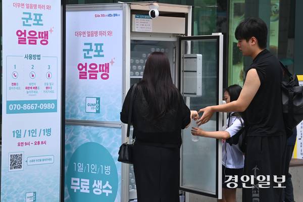 무더운 날씨가 이어진 18일 오후 군포시 산본로데오거리에 설치된 무인 냉장고 ‘군포 얼음땡’에서 시민들이 물을 가져가고 있다. 2025.8.18 /최은성기자 ces7198@kyeongin.com