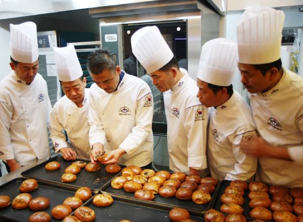 최권수 우리밀 발전협의체 회장이 우리밀 빵 기술을 동료들에게 알려주고 있다.