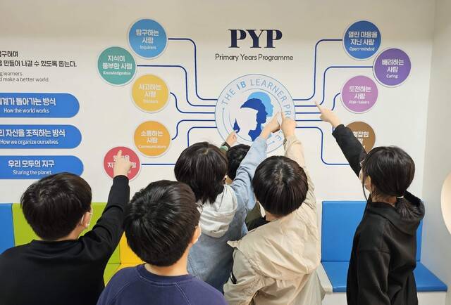 IB PYP 후보학교로 운영되고 있는 삼덕초에서 학생들이 PYP 탐구 프로그램 개요도를 살펴보고 있다. 삼덕초 제공
