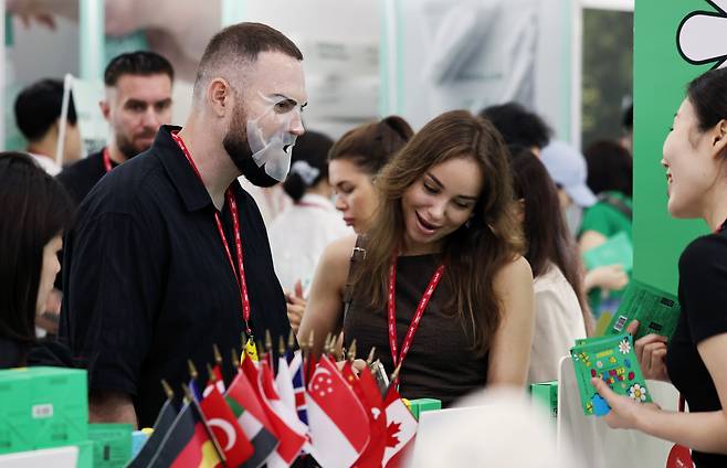 지난 7월 서울 강남구 코엑스에서 열린 글로벌 뷰티·화장품 전문 전시회 '2025 인터참코리아'에서 외국인 참관객이 마스크팩을 착용하고 있다. 2025.7.2/뉴스1