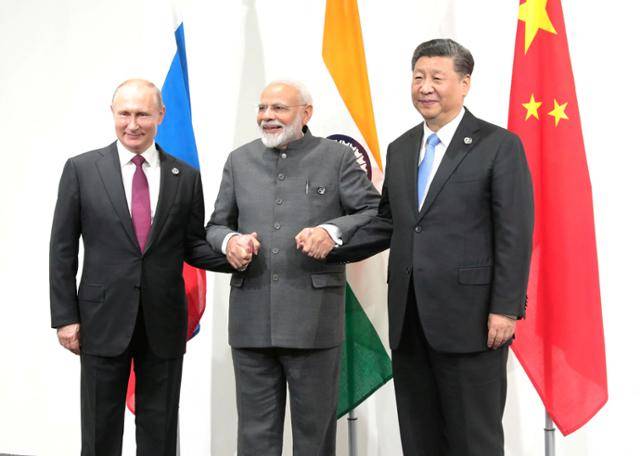 지난 2019년 일본 오사카에서 열린 G20 정상회의에서 블라디미르 푸틴(왼쪽) 러시아 대통령과 나렌드라 모디(가운데) 인도 총리, 시진핑 중국 국가주석이 손을 맞잡고 있다. 오사카=스푸트니크·로이터 연합뉴스 자료사진