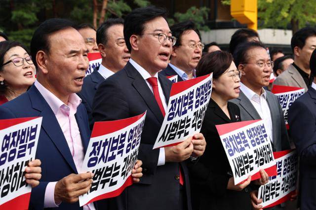 송언석 비상대책위원장 겸 원내대표를 비롯한 국민의힘 의원들이 18일 서울 서초구 서울중앙지방법원 앞에서 열린 현장비상의원총회에서 구호를 외치고 있다. 뉴스1