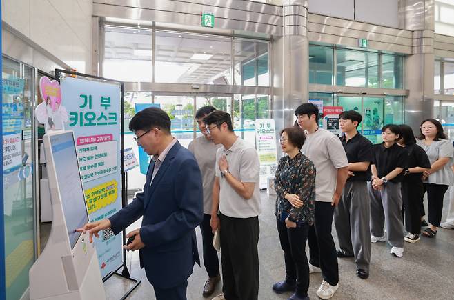 대전 유성구청 직원들이 이동형 기부 키오스크를 이용해 기부를 실천하고 있다. 유성구