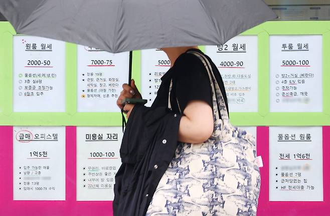 서울 시내 한 부동산 전월세 관련 안내문 앞을 시민이 지나가고 있다. 올해 1분기 서울 주택임대계약의 총 23만3958건 중 월세 계약은 15만1095건으로 64.6%를 차지했다.  연합뉴스