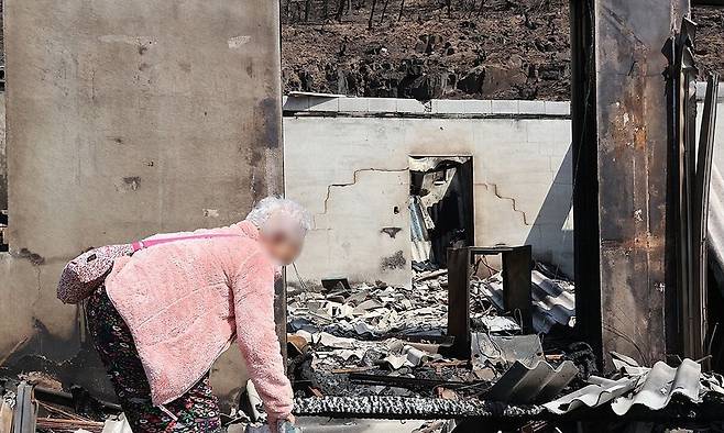 산불이 휩쓸고 간 지난 3월29일 경북 의성군 하화리에서 한 주민이 폐허가 된 주택을 바라보고 있다. 연합뉴스