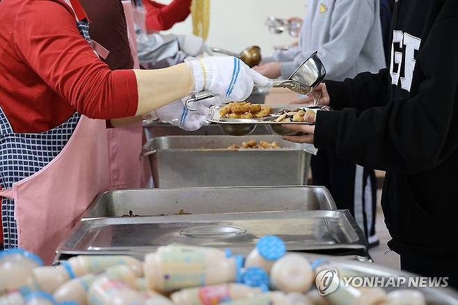 급식 배식 받는 둔산여고 학생들 (대전=연합뉴스) 이주형 기자 = 대전 서구 둔산여고가 지난 2일부터 저녁 급식 제공을 중단한 가운데, 지난 4월11일 오후 이 학교 급식실에서 학생들이 점심을 받고 있다. 2025.4.11 coolee@yna.co.kr