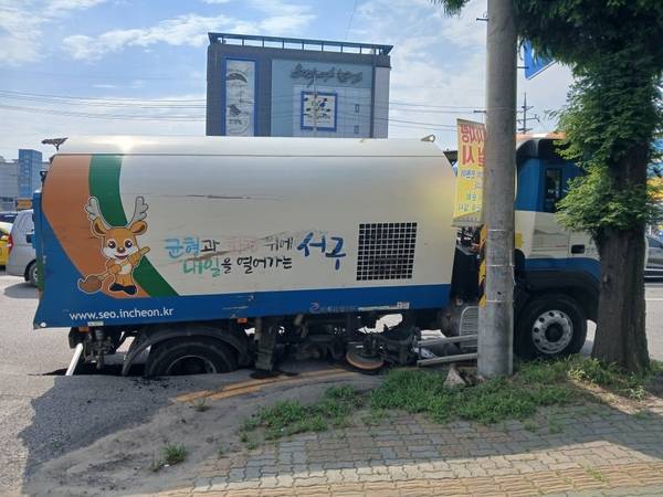 18일 오후 3시22분께 인천 서구 석남동 도로에 땅 꺼짐이 발생해 청소차 뒷바퀴가 빠졌다.  /인천소방본부 제공