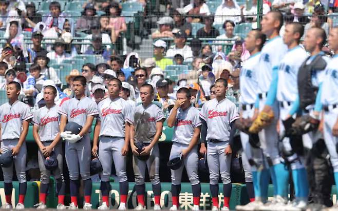 재일 한국계 교토국제고 야구부가 19일 전국고교야구선수권대회(여름 고시엔) 8강전에서 탈락한 뒤 고시엔 구장 한편에서 승리교의 교가를 들으면서 눈물을 훔치고 있다./산케이스포츠 디지털