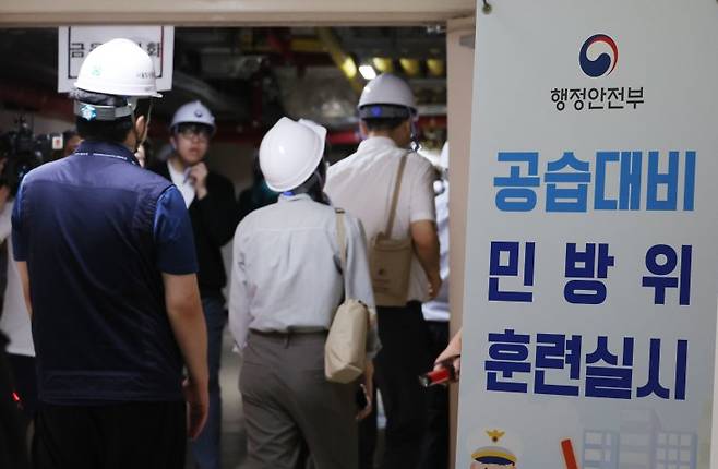 지난해 8월 22일 서울 종로구 정부서울청사에서 열린 공습대비 민방위 훈련에 참가한 공무원들이 지하대피소로 이동하고 있다.뉴시스