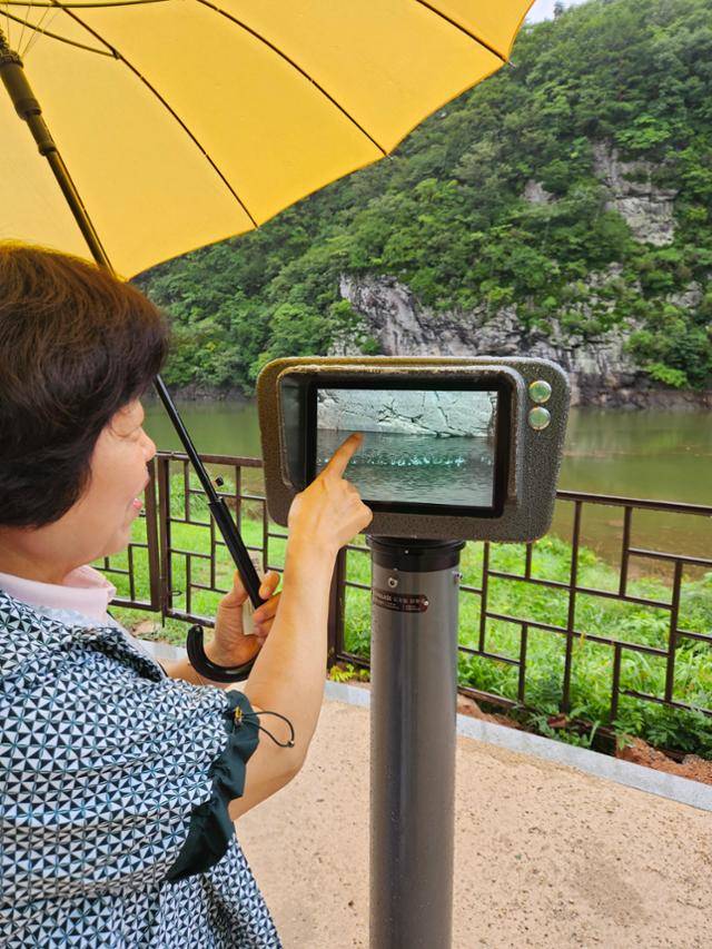 지난 12일 울산 울주군 언양읍 대곡리 반구대 전망대에서 정윤점 문화관광해설사가 디지털 망원경으로 암각화 중 침수되지 않은 부분을 찾고 있다. 울산=박은경 기자