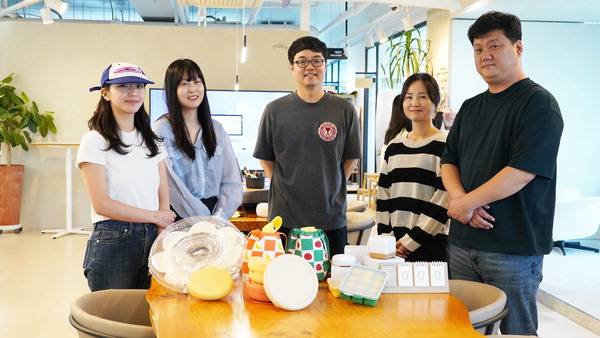 19일 부산 해운대구 말랑하니 사옥에서 박성준(가운데) 대표와 직원들이 자사에서 출시한 육아용품을 소개하고 있다.  말랑하니 제공