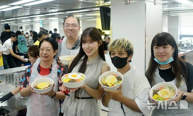 [전주=뉴시스] 김얼 기자 = 이다혜(가운데) 대만 웨이취안 드래곤스 치어리더가 18일 전북 전주시 한국전통문화전당을 찾아 전주비빔밥 만들기 체험을 하며 대만 팬들과 함께 기념촬영을 하고 있다. 치어리더 이다혜는 오늘 전주한옥마을을 방문하고 완주 대승한지마을에서 전북특별자치도 관광홍보대사로 위촉된다. 2025.08.18. pmkeul@newsis.com