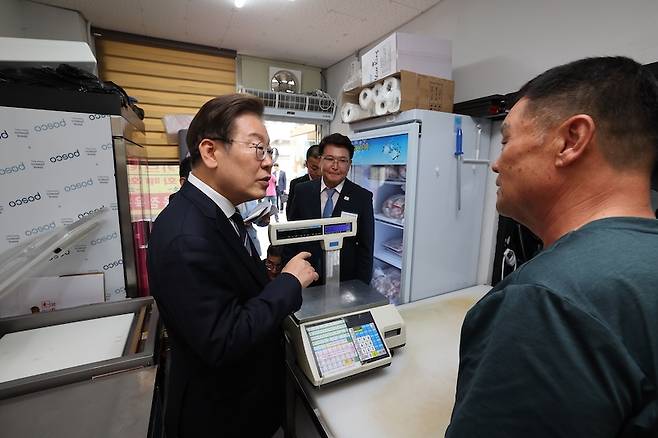 이재명 대통령이 지난 6월 13일 기본소득 실시 지역 현황 점검을 위해 방문한 경기도 연천군 정육점에서 주민과 대화하고 있다. [사진 | 뉴시스]