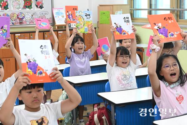 20일 오전 수원시 팔달구 매산초등학교에서 여름방학을 마치고 개학한 3학년 학생들이 교과서를 들어 보이며 환하게 웃고 있다. 2025.8.20 /최은성기자 ces7198@kyeongin.com