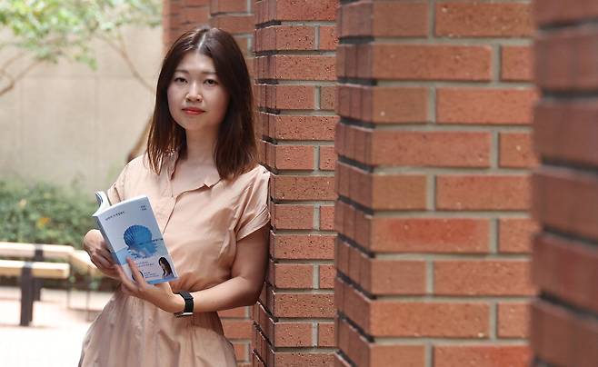 소설가 김초엽이 20일 서울 정동에서 새 소설집을 들고 포즈를 취하고 있다.  이승환 기자