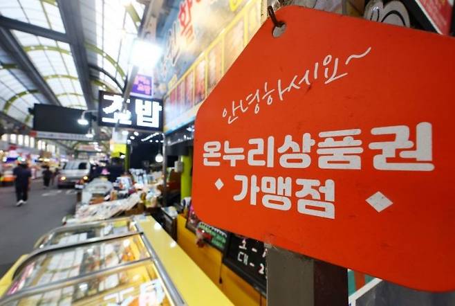 정부가 신용카드 사용실적 증가분의 일정액을 온누리상품권으로 환급해주는 ‘상생페이백’ 사업을 내달 시행한다. 사진은 서울의 한 전통시장 상점에 걸린 온누리상품권 안내 팻말. [연합]