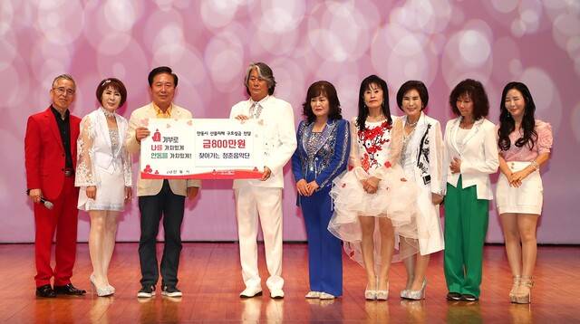 정태섭씨(왼쪽 네번째)가 6월29일 산불피해 이재민 위로 자선콘서트를 마친후 권기창 안동시장(왼쪽 세번째)에게 수익금 800만원을 전달하고 있다.