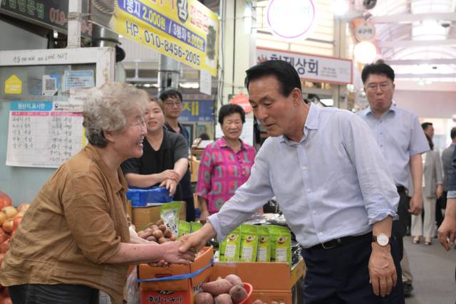 ▲장보기 행사 현장, 상인의 손을 잡으며 이야기를 나누는 백성현 논산시장.