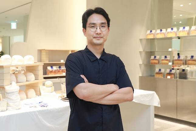 박형진 현대백화점 영업본부 크리에이티브부문 카페랩 팀장이 틸화이트의 베이커리 진열대 앞에서 포즈를 취하고 있다. / 사진=현대백화점그룹