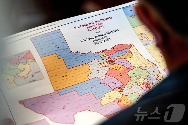 20일 텍사스 오스틴 주의회에서 열린 입법 회의 중 공화당 소속 맷 모건 의원이 새로 제안된 연방 하원 선거구 지도를 들고 있다. ⓒ 로이터=뉴스1