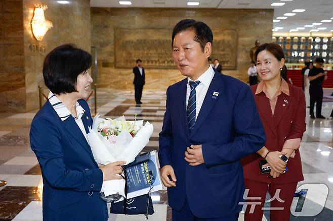추미애 신임 법제사법위원회 위원장이 21일 서울 여의도 국회 본회의장 앞에서 법사위 직원들로부터 꽃다발을 받은 뒤 정청래 더불어민주당 대표의 축하를 받고 있다. 2025.8.21/뉴스1 ⓒ News1 안은나 기자