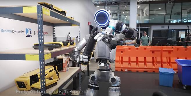 보스턴다이나믹스 아틀라스가 로봇 개 '스팟' 다리 부품을 정리하고 있다. 사진=보스턴 다이내믹스 유튜브 화면 캡처