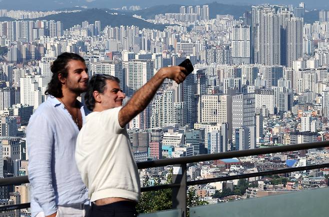 Tourists takes photos on Mount Namsan in central Seoul on Aug. 21. [YONHAP]
