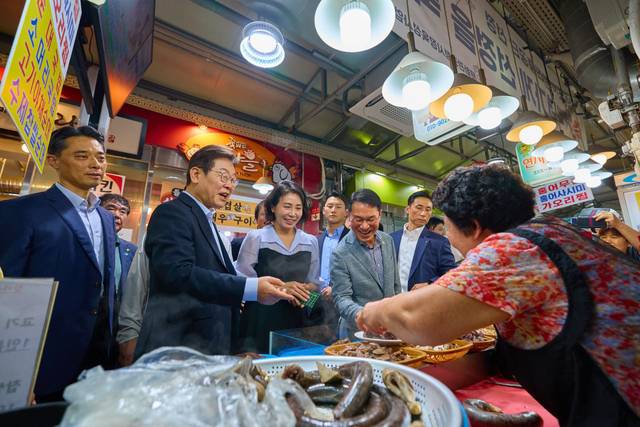 이재명 대통령과 김혜경 여사가 17일 서울 은평구 연서시장을 방문해 순대 등을 구매하고 있다.  이날 이 대통령은 민생회복 소비쿠폰 효과 민심 청취를 하며 생활용품과 찬거리를 온누리상품권으로 구매했다. 대통령실 제공 및 뉴시스