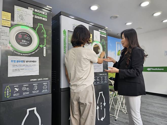 박은정 플라스틱히어로코리아 대표(오른쪽)가 자사의 폐플라스틱 수거 및 재활용 AI 기기인 플라스틱히어로 AI로봇을 찾은 고객에게 유용한 사용법을 설명하고 있다. 박 대표는 이 기기를 하도 많이 공부해 어쩌다 이상음이 들리면 금방 무엇이 문제인지, 어떻게 고쳐야 하는지 알 정도로 플라스틱AI로봇에 관한한 박사급이 됐다고 한다.  <사진=플라스틱히어로코리아>