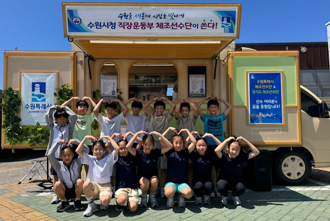 수원시 체조선수단이 커피 차 앞에서 기념사진을 찍고 있다. 사진=수원시청