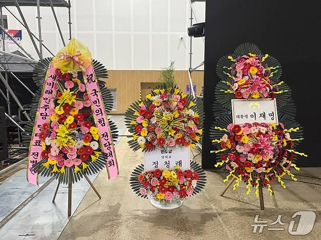 22일 국민의힘 전당대회가 열리는 충북 청주 오스코 행사장에 이재명 대통령, 정청래 더불어민주당 대표, 전병헌 새미래민주당 대표의 축하 화환이 놓여져 있다. ⓒ 뉴스1 홍유진 기자